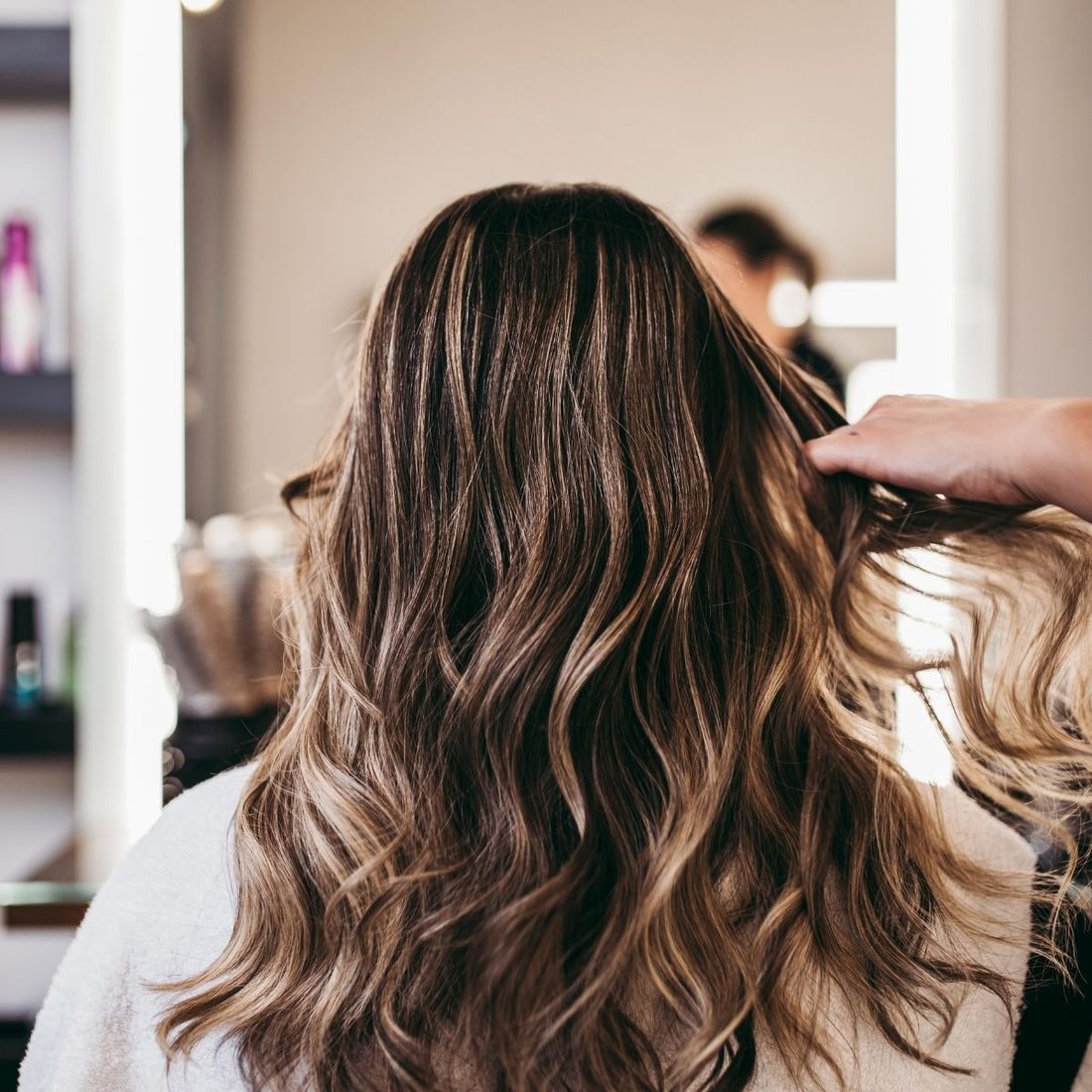 Friseurin passt eine Perücke individuell an